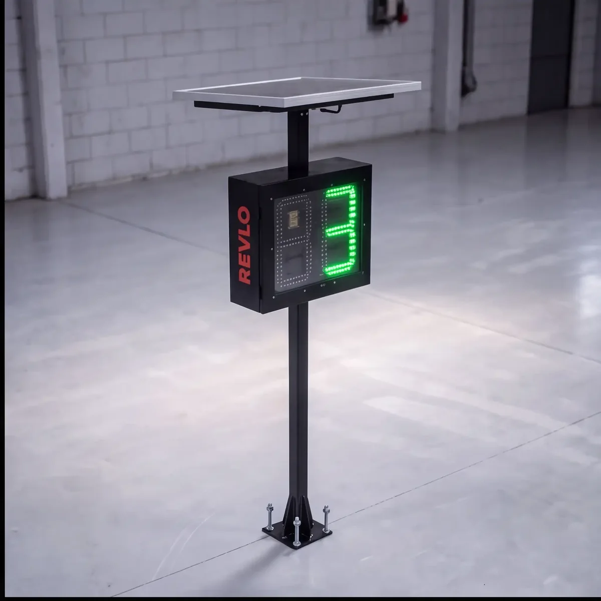 Lombada eletrônica Revlo instalada sobre coluna chumbada no piso, com painel solar no topo e a velocidade em LED verde