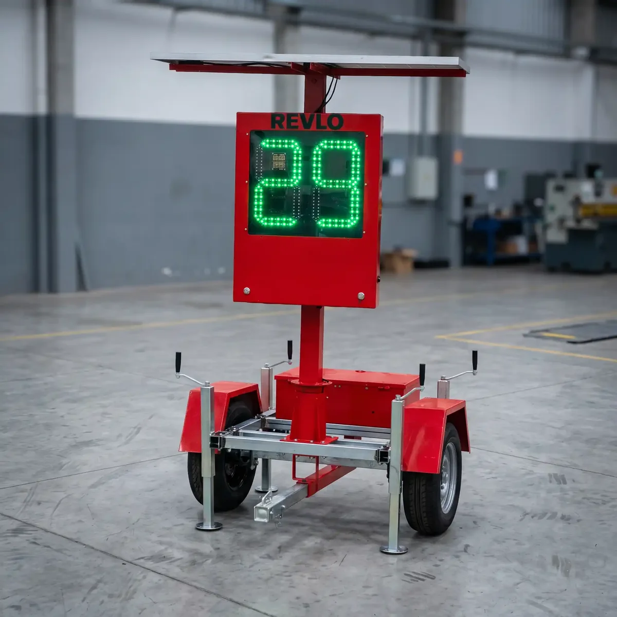 Lombada eletrônica móvel Revlo montada em reboque vermelho, com painel solar no topo e a velocidade em LED verde